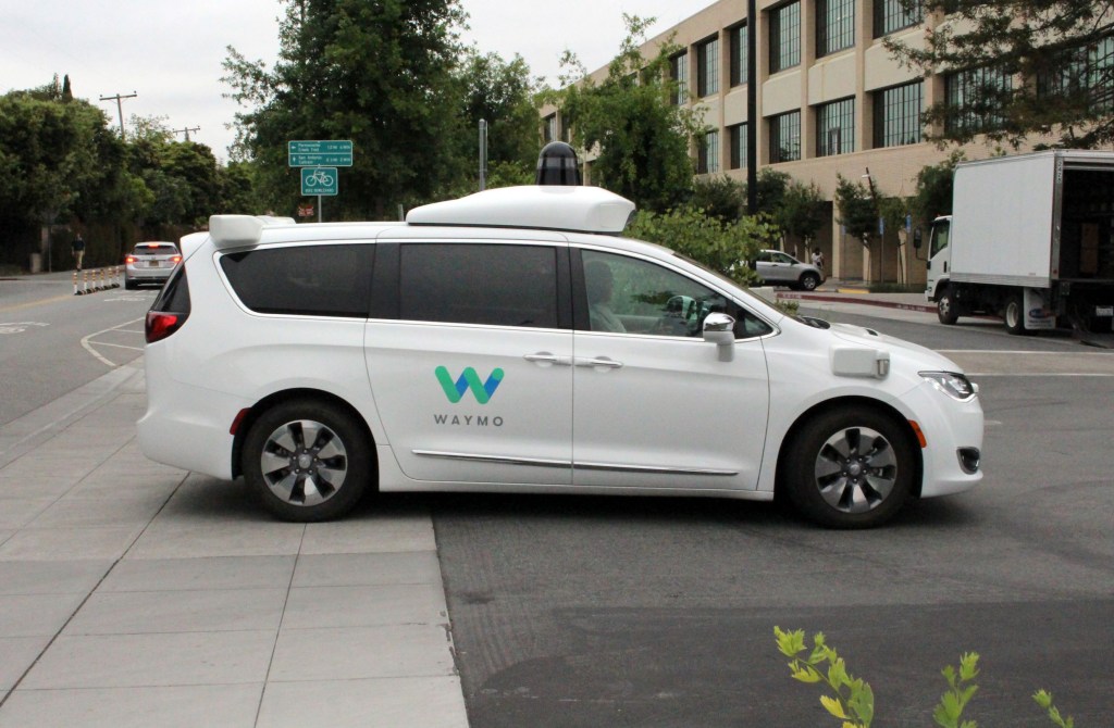 A white Waymo autonomous test car pulls into the company's California headquarters
