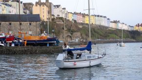 A yacht owner tries to start the engine in Tenby Harbour where Pleasure and Working boats are being returned to the sea on Spring High Water