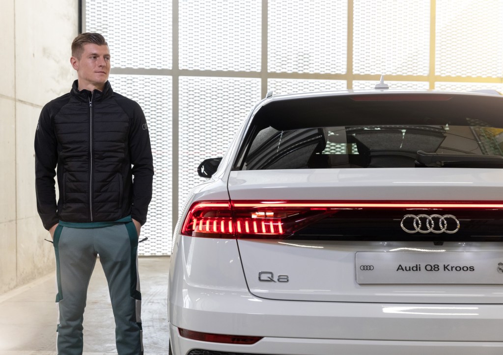 Toni Kroos stands next to a new white Audi Q8 