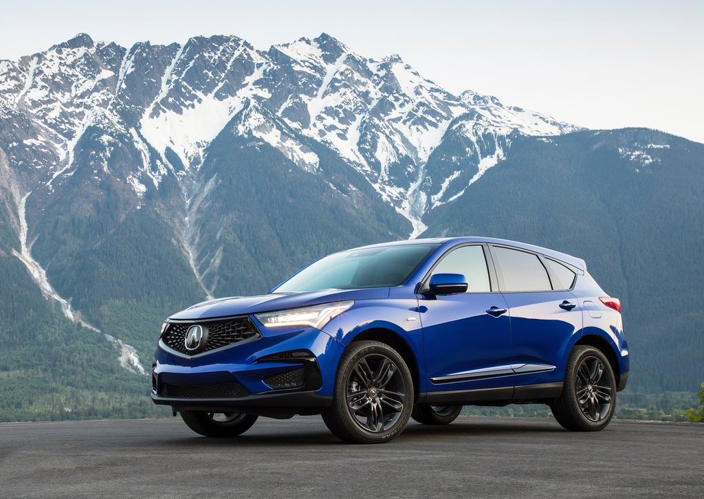 a front shot of a blue 2019 Acura RDX in front of a mountain range