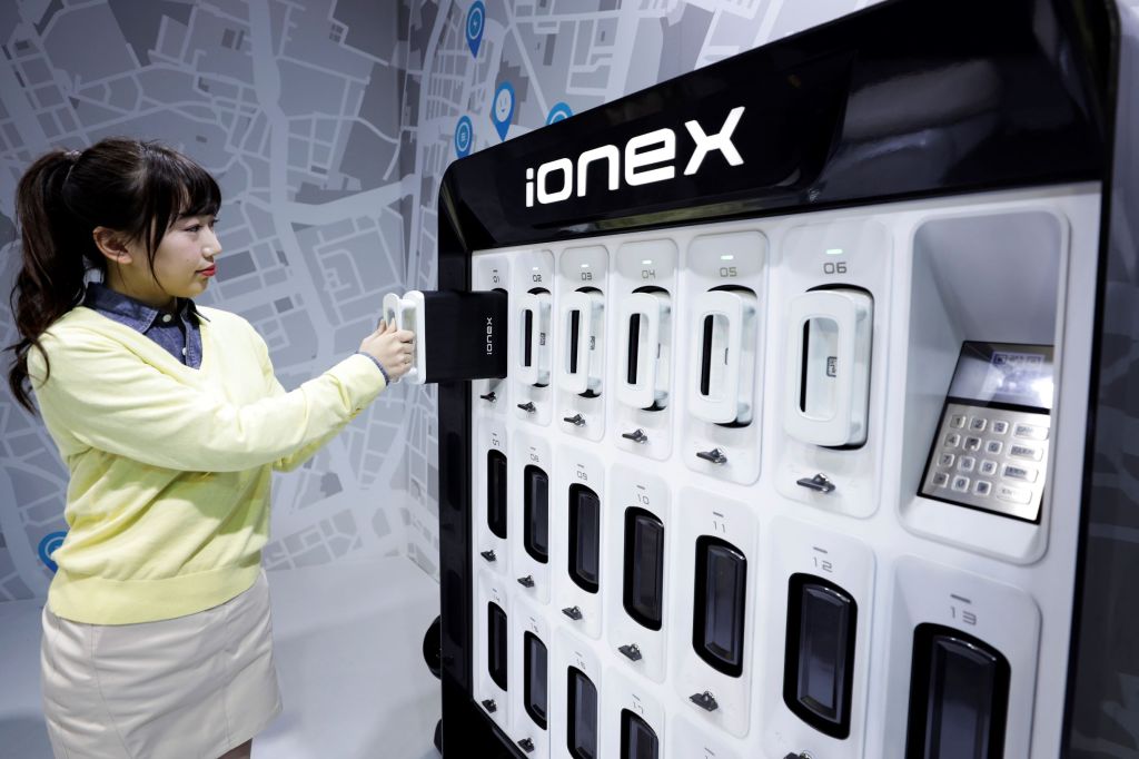 An attendant demonstrates the Kymco Ionex battery swap station