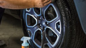 A worker applies Chemical Guys Tire Kicker tire shine