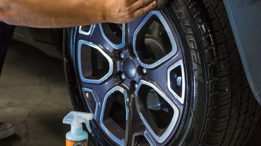 A worker applies Chemical Guys Tire Kicker tire shine