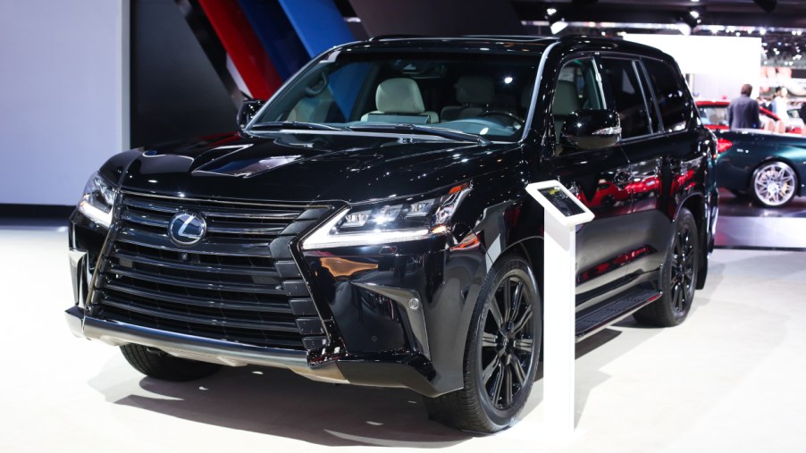 A black Lexus LX on display at an auto show