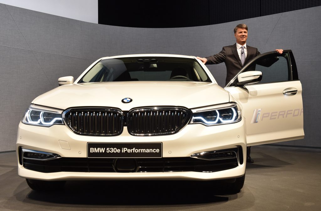 A BMW employee poses next to a 530e