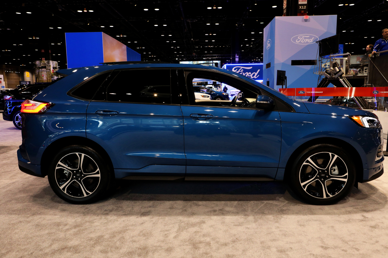 A blue Ford Edge on display at an auto show