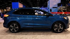 A blue Ford Edge on display at an auto show
