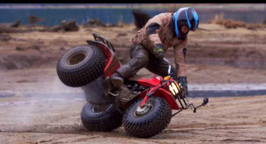 a three-wheeled ATV crashing in the dirt