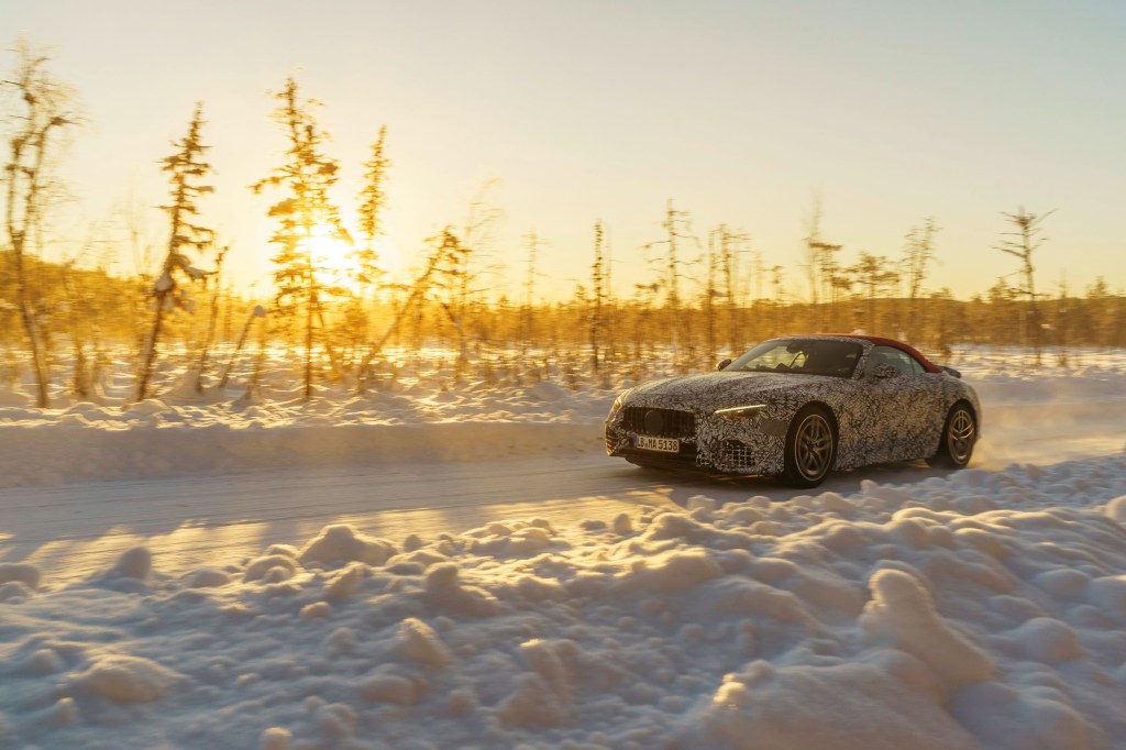 A camouflaged 2022 Mercedes-AMG SL with a red roof undergoing winter testing