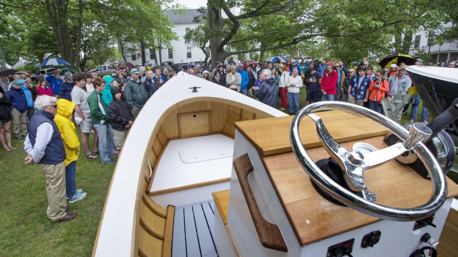 A large crowd gathers to watch students from the Landing School christen newly finished boats in Kennebunkport