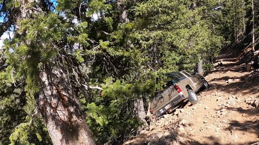 A very stuck Chevy Silverado stuck on the side of a cliff