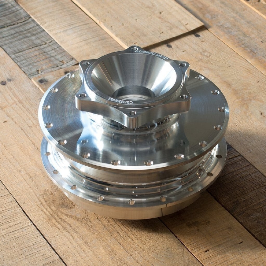 An aluminum Cognito Moto 1969-1982 Honda CB750 rear disc brake conversion hub on a wooden table