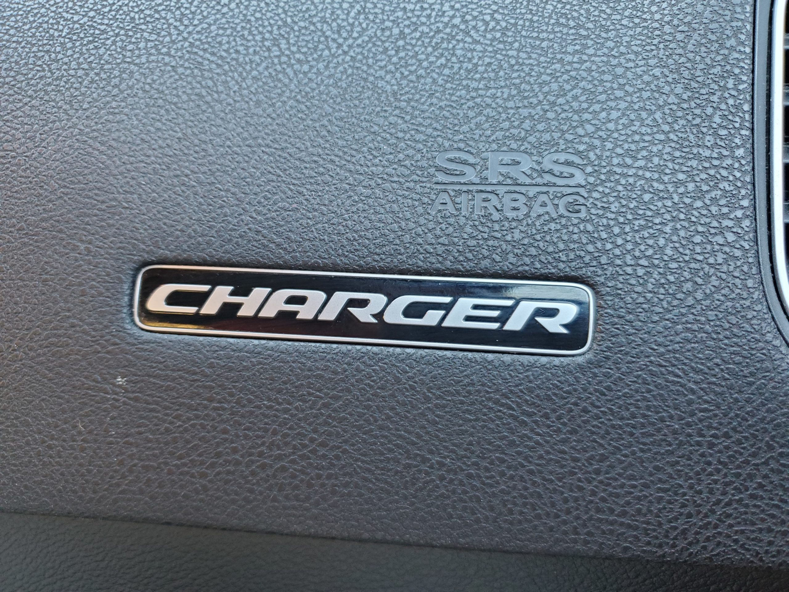 Close-up of the Dodge Charger logo on a car dashboard