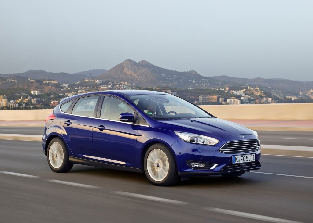 A blue 2015 Ford Focus driving down the road