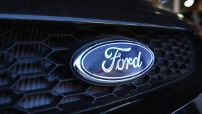 The blue oval Ford logo on the grill of a dark-colored car