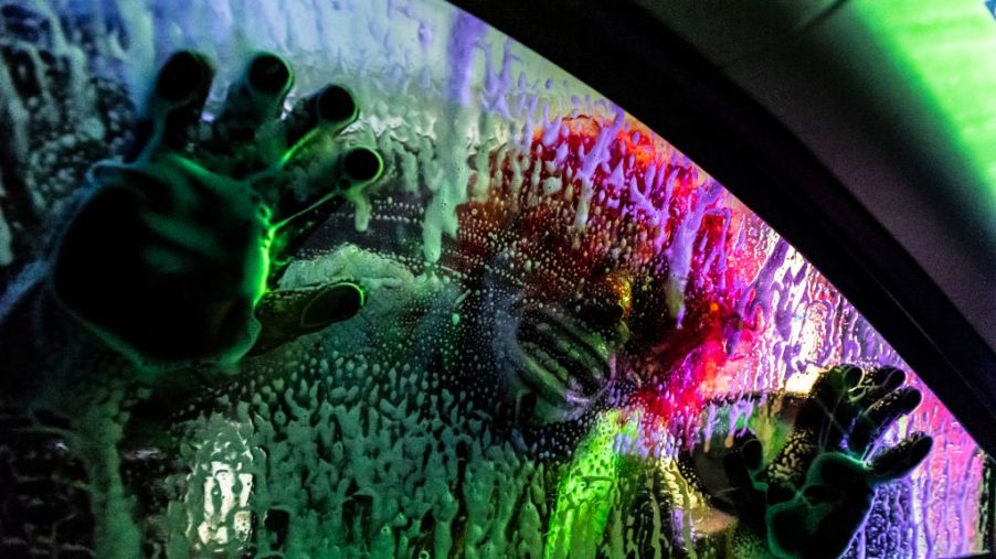 A scary clown pressed its face against a soapy car window in a haunted house