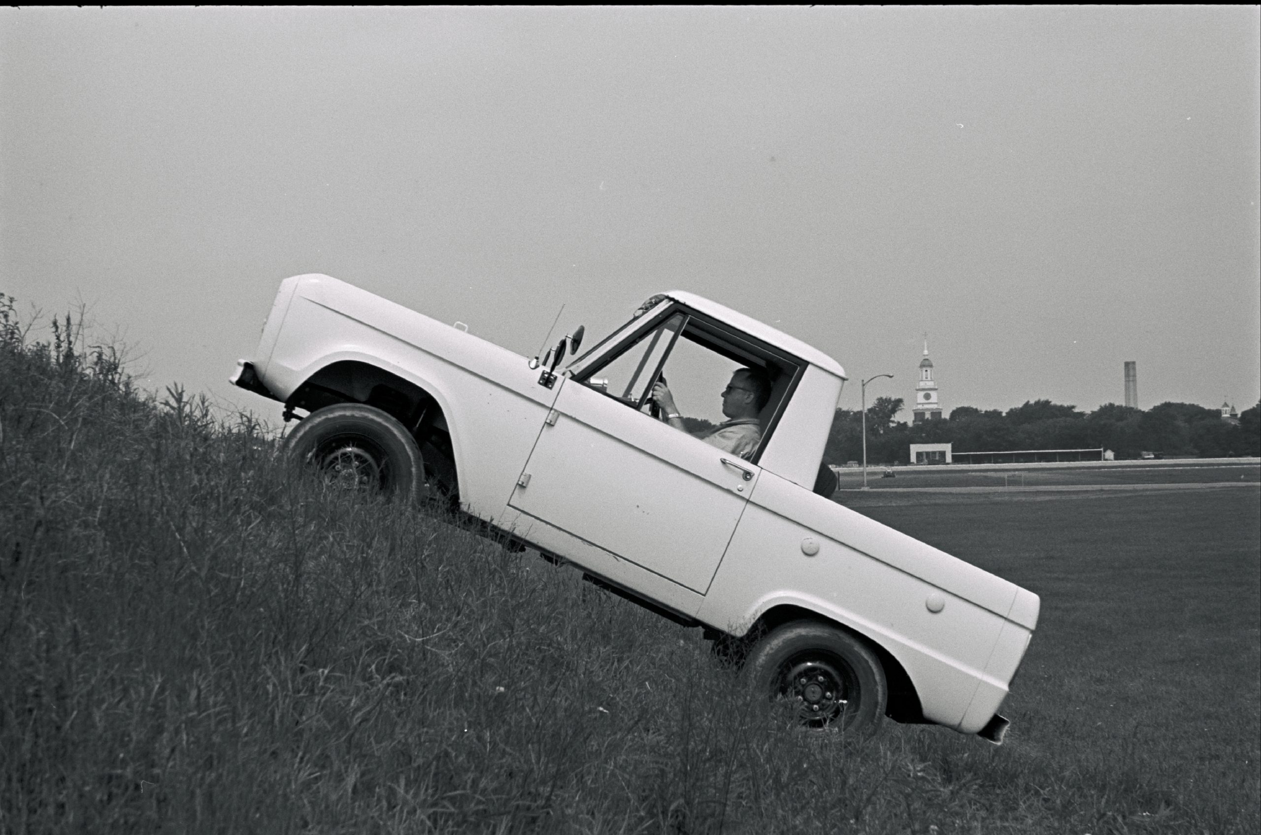 A 1966 Ford Bronco climbing a steep hill