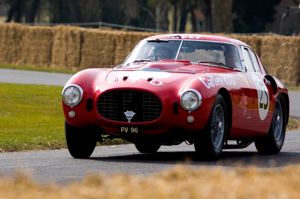 An image of a red Ferrari 375 MM parked outdoors.