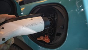 An individual plugs in an electric vehicle charger