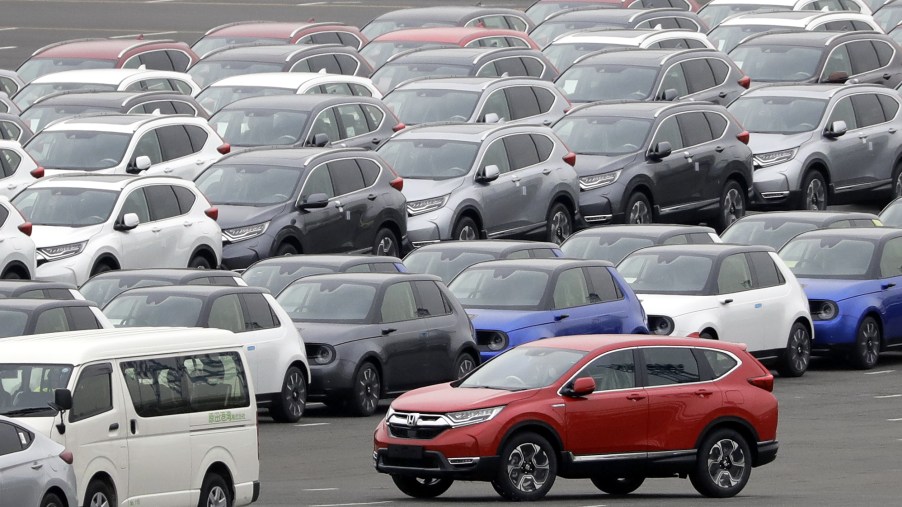 A Honda Motor Co. CR-V sports utility vehicle (SUV) bound for shipment, bottom right, is driven while others sit parked at a port in Yokohama, Kanagawa Prefecture, Japan