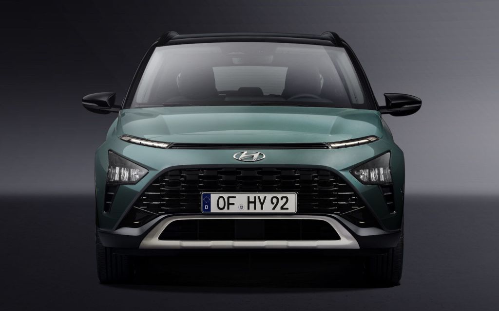 A look at the front end of a green Hyundai Bayon in front of a grey background
