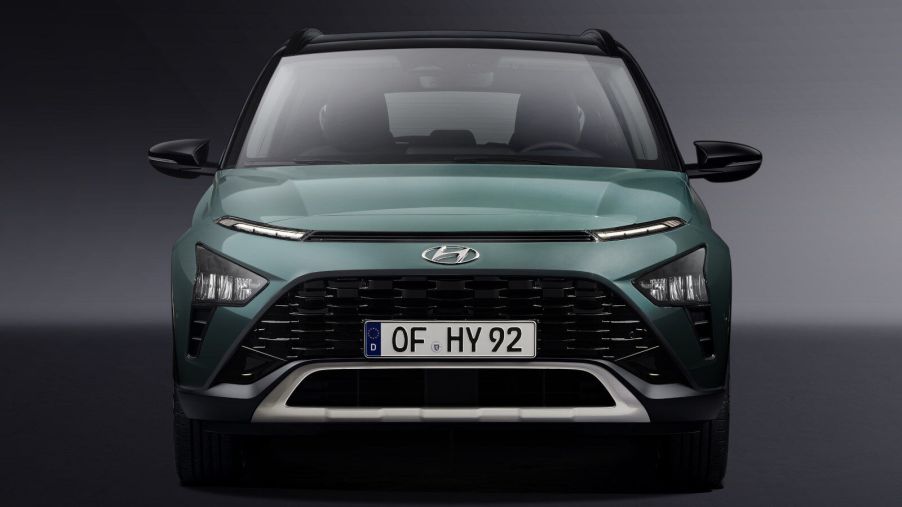A look at the front end of a green Hyundai Bayon in front of a grey background