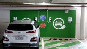 A white Hyundai KONA Electric charges at a EV charge station in Crows Nest
