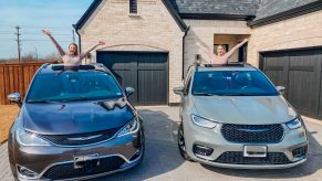 two moms with their pacifica minivans side by side posing out of the sun roofs