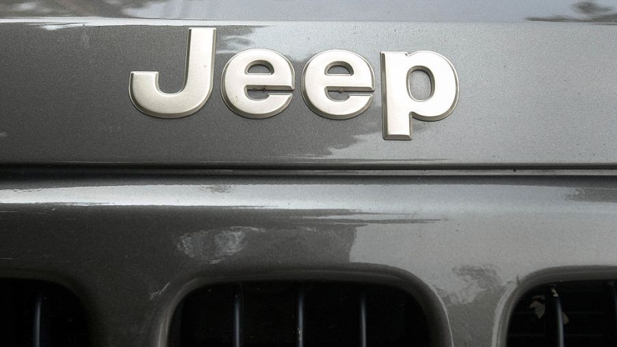 Closeup of the Jeep logo across the bumper of a gray Jeep Cherokee