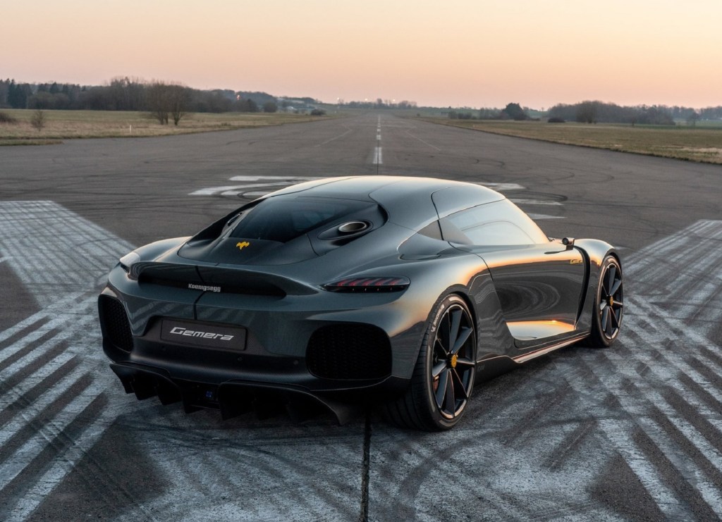 The rear 3/4 view of a gray Koenigsegg Gemera on an airport runway