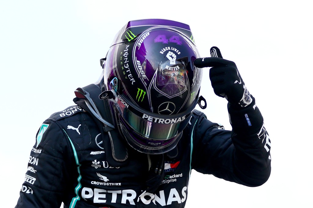 Race winner Lewis Hamilton of Great Britain and Mercedes GP points to the 'Black Lives Matter' symbol on his helmet.