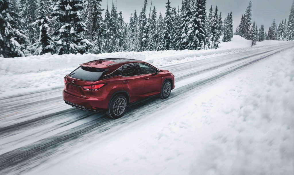 2021 Lexus RX 350, a consumer reports recommended SUV in red driving through the snow 