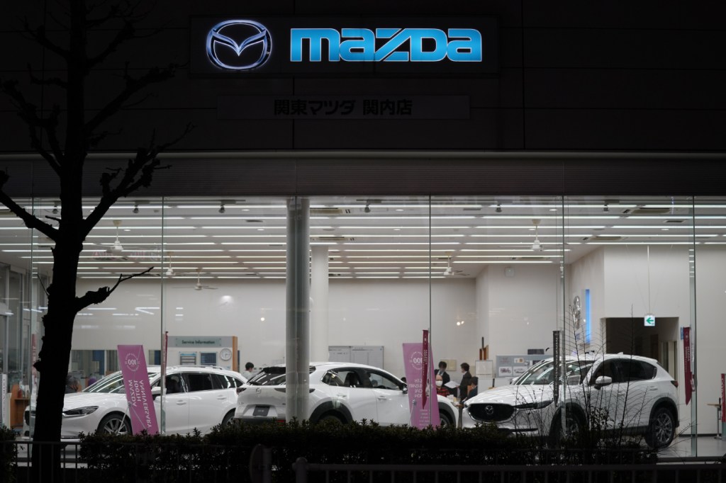 Cars on display in the window of a Mazda dealership
