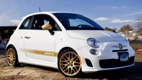 A modified white-and-gold 2013 Fiat 500 Abarth in a snowy dirt field