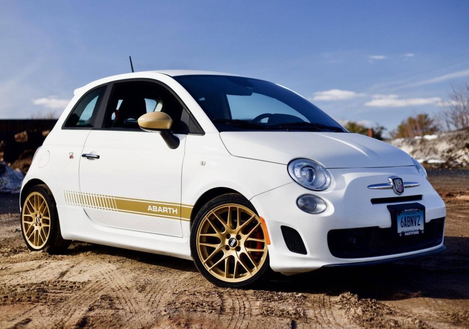 A modified white-and-gold 2013 Fiat 500 Abarth in a snowy dirt field