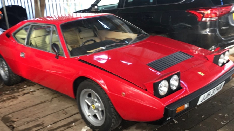 An image of a red Ferrari Dino 308 GT4 parked outdoors.