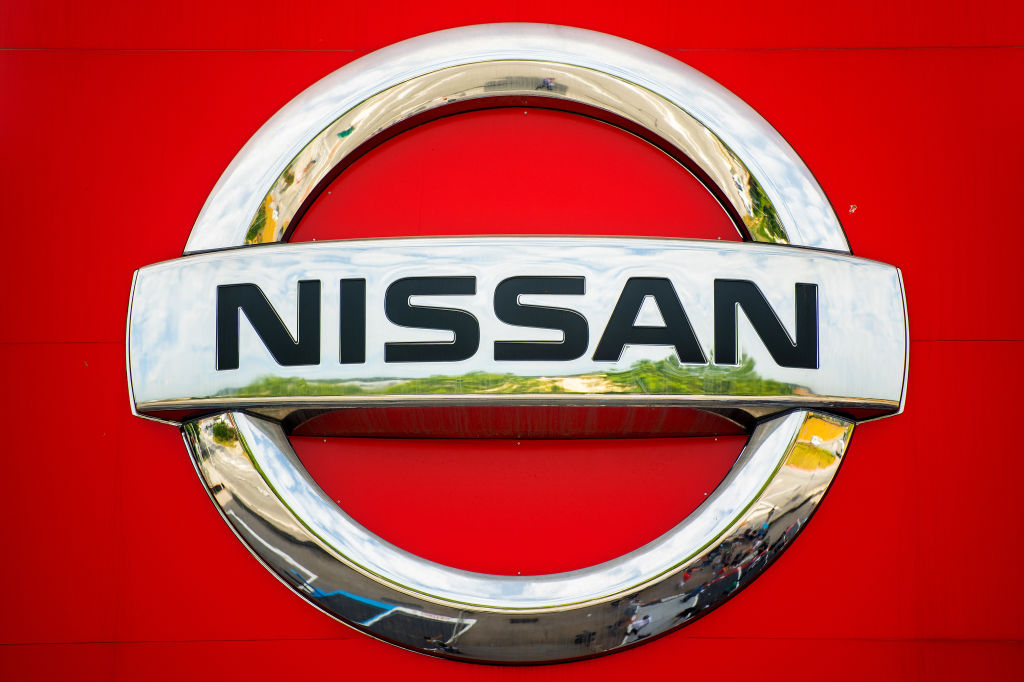 A chrome Nissan logo on a red vehicle