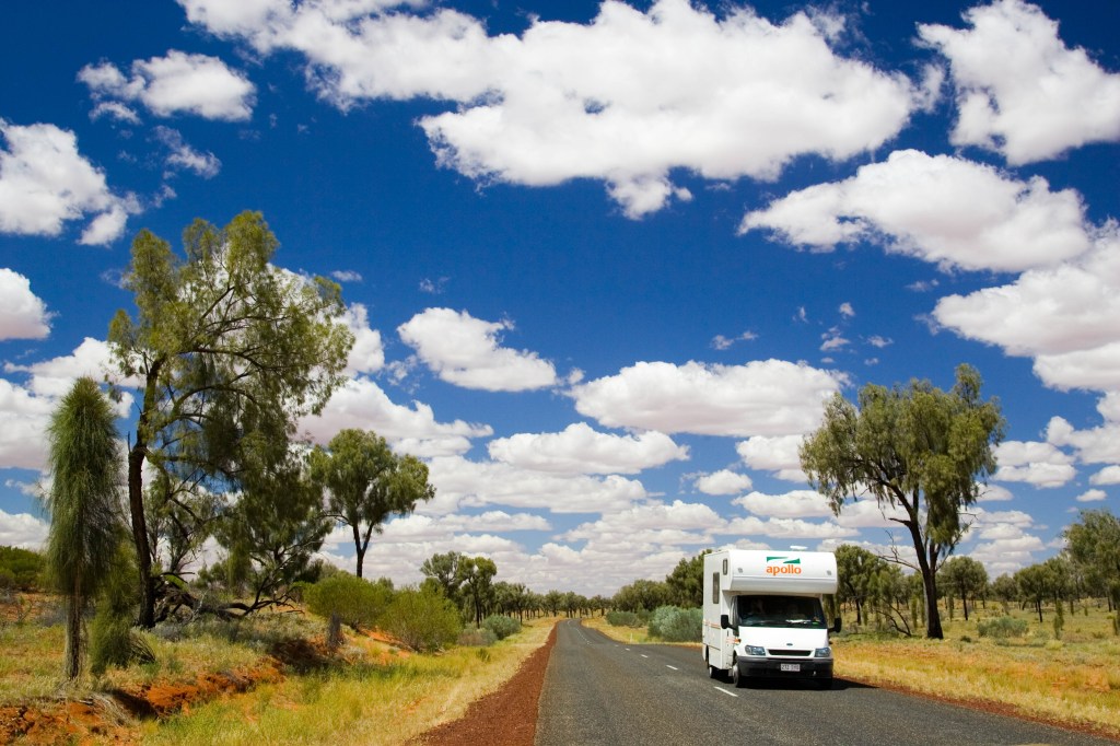 A white RV traveling through the Australian countryside