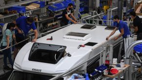 Employees fit the roof to a motorhome RV on the Knaus Tabbert AG assembly line