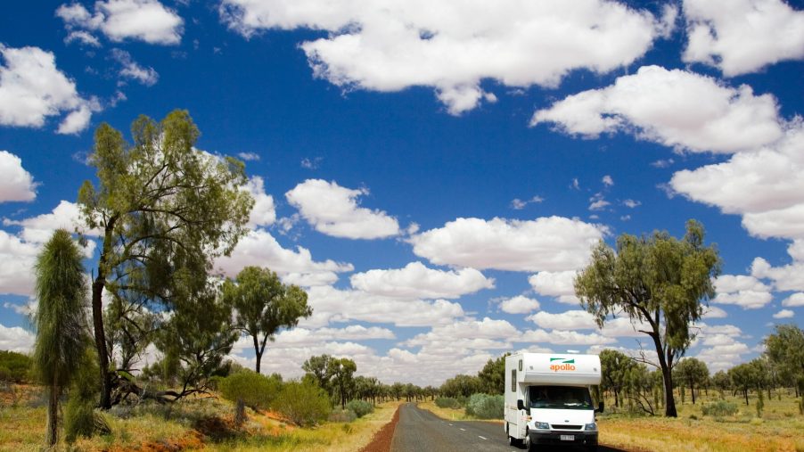 A white RV driving through the Australian countryside