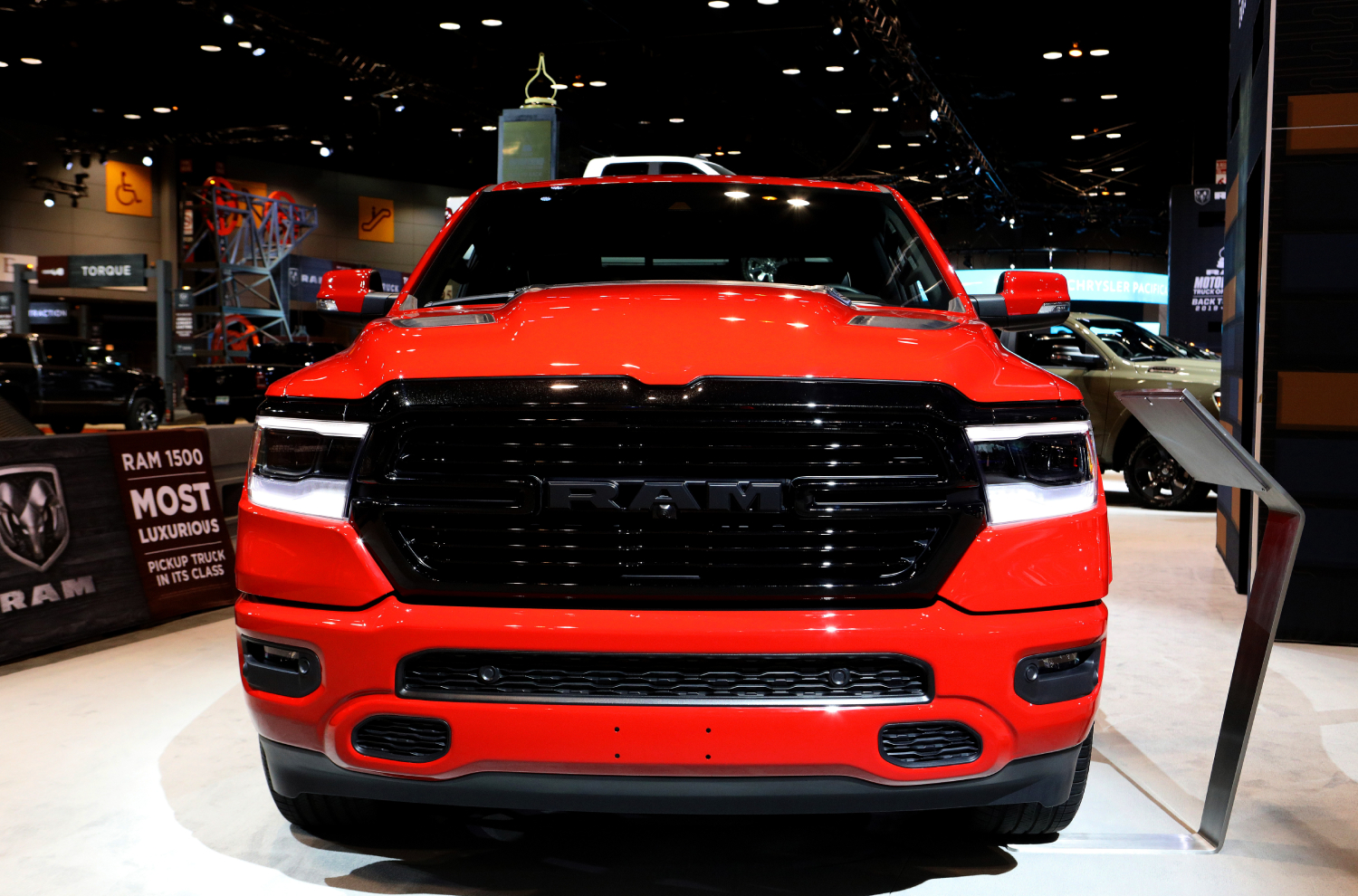 A red Ram 1500 Laramie pickup truck is on display at an auto show