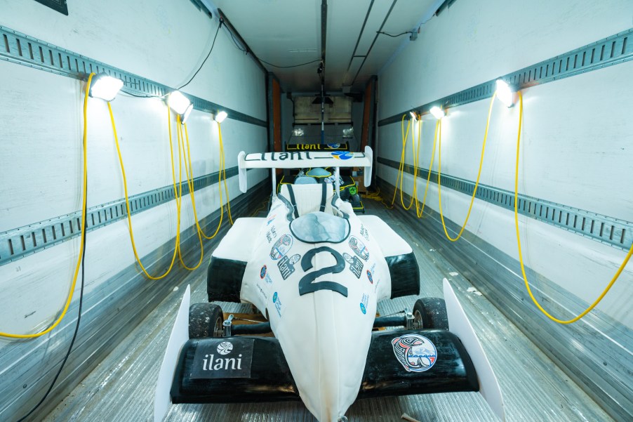 A white formula 1 race car made of cake and fondant sits in a cooled trailer