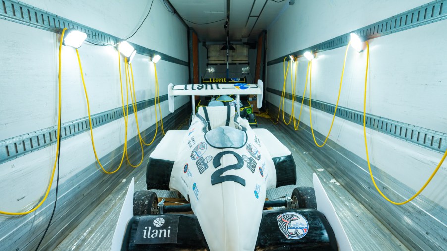 A white formula 1 race car made of cake and fondant sits in a cooled trailer