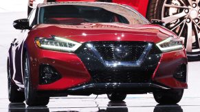 A red Nissan Maxima on display at an auto show