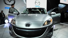 A silver Mazda3 on display at an auto show