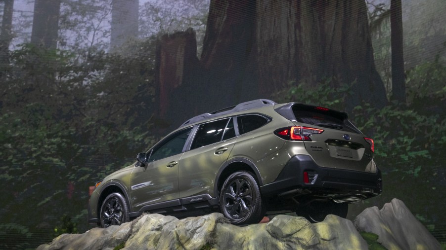 A Subaru Outback traverses a rock at a car show in 2020