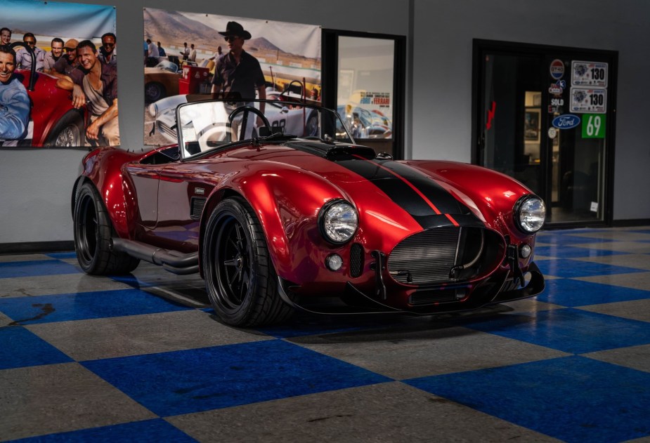 A red-with-black-stripes Superformance MKIII-R with Godzilla V8 inside a dealership