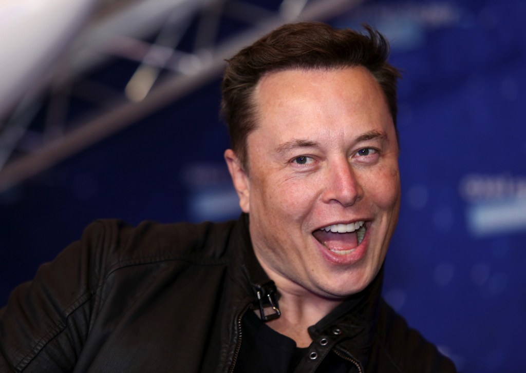 Tesla CEO Elon Musk, smiling and wearing a black moto jacket, arrives at the Axel Springer Award ceremony in Berlin, Germany, on Tuesday, December 1, 2020