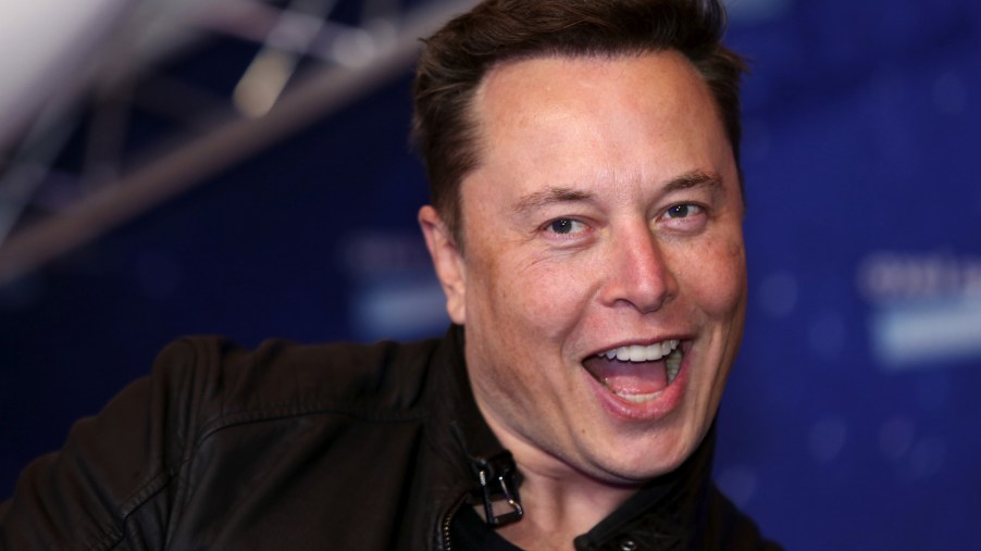 Tesla CEO Elon Musk, smiling and wearing a black moto jacket, arrives at the Axel Springer Award ceremony in Berlin, Germany, on Tuesday, December 1, 2020