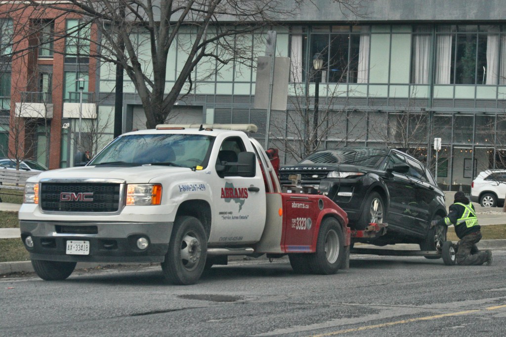 Tow truck towing a beat up Range Rover